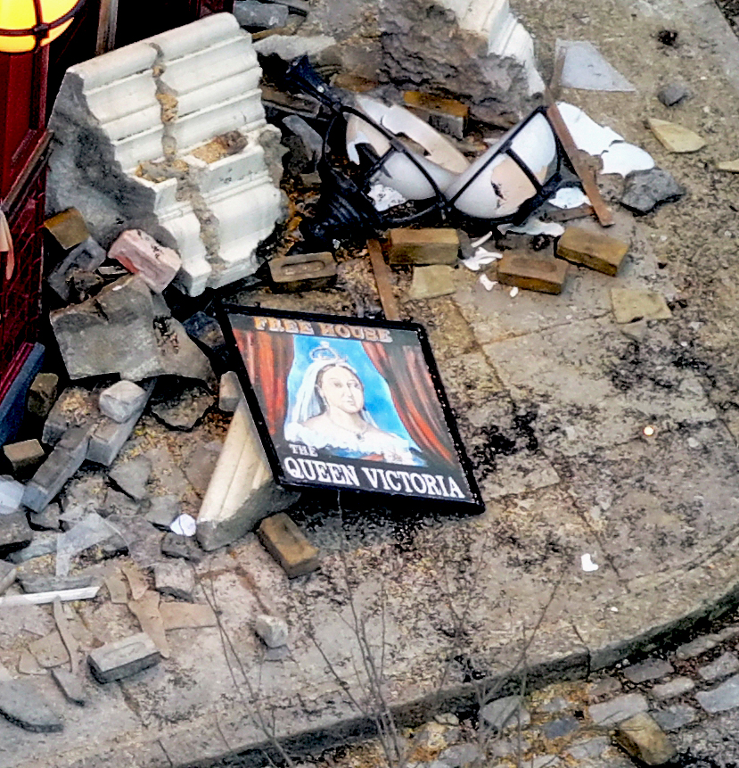 Debris and the Queen Victoria pub sign after an explosion.