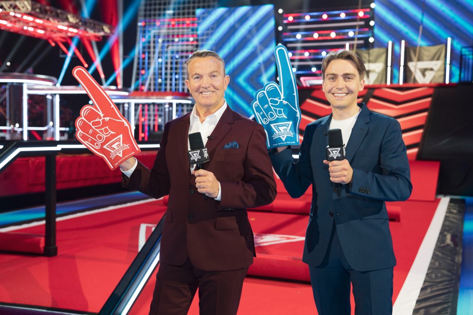 Bradley and Barney Walsh, presenters of Gladiators, holding microphones and foam fingers.