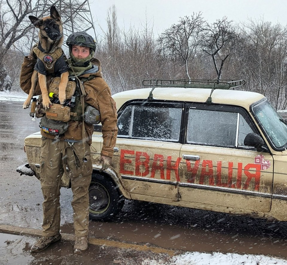 British humanitarian worker Edward Scott in Ukraine, holding his dog, standing by a muddy car.