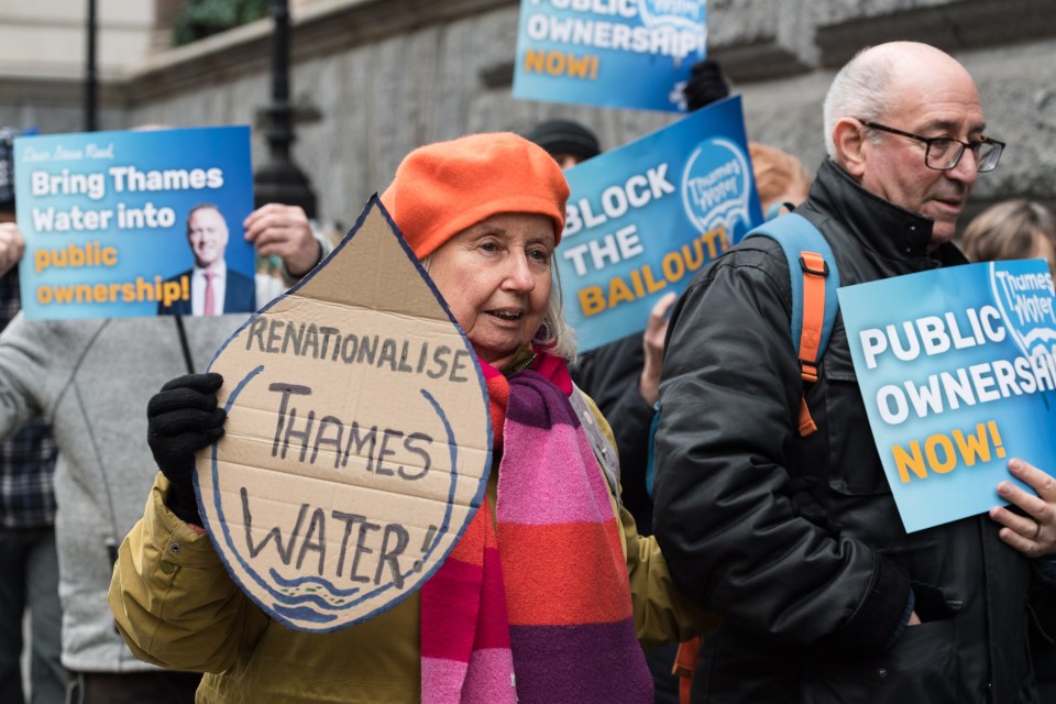 Protestors holding signs advocating for Thames Water to be brought into public ownership.