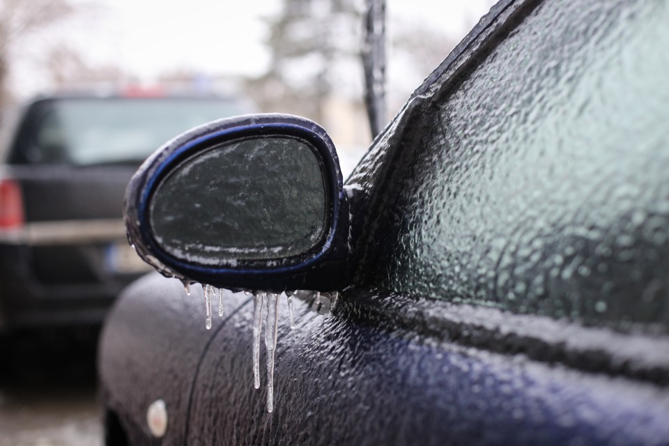 Frozen car side mirror with icicles.