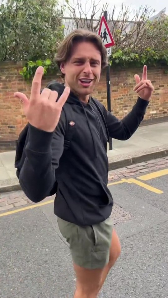 Casey O'Gorman making hand gestures on a street.