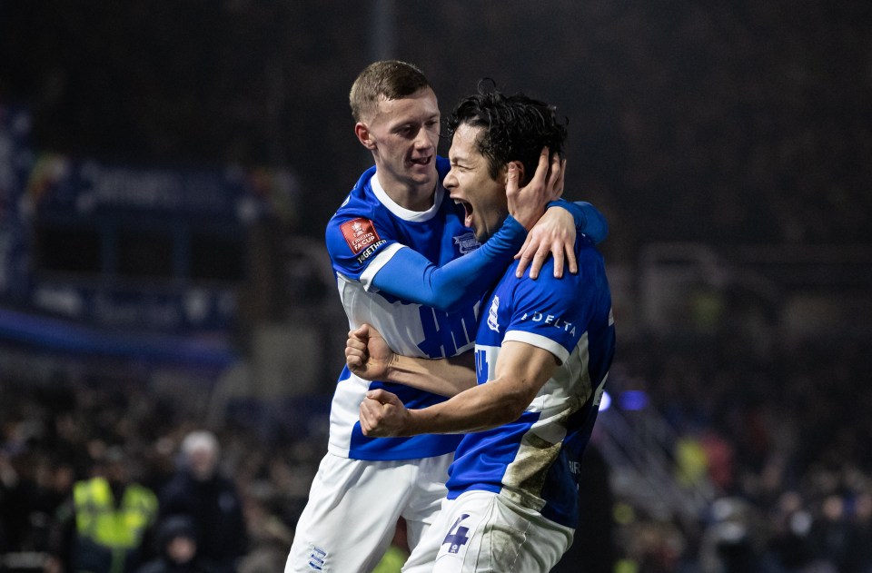 Two soccer players celebrating a goal.