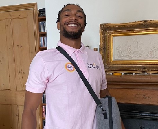 Man in pink polo shirt with "Beyond Recovery" logo.