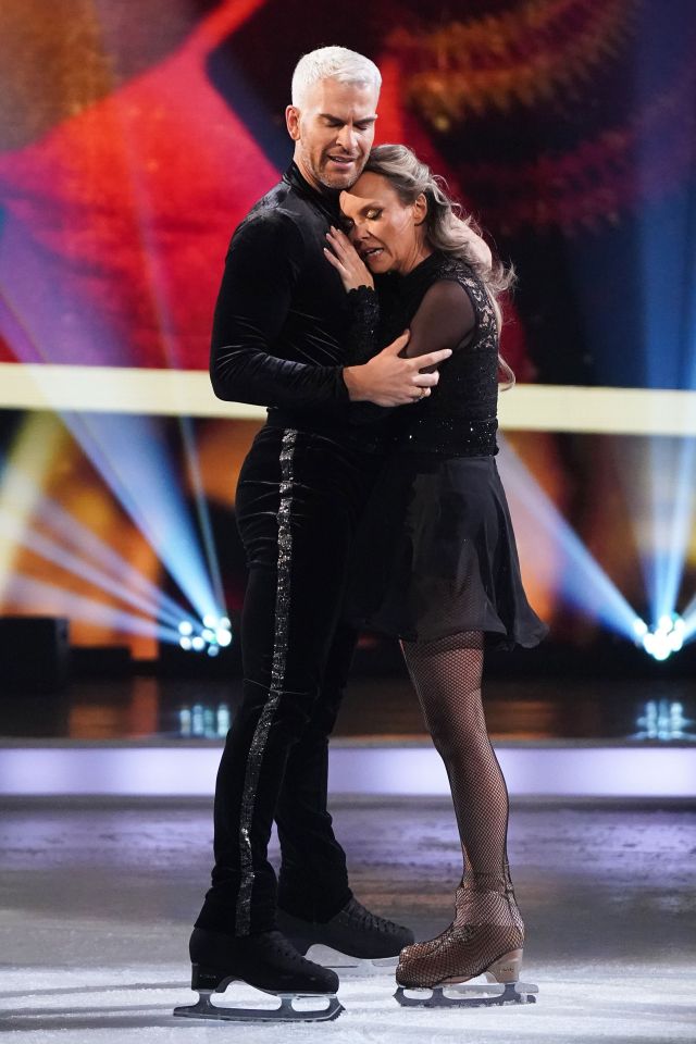 Charlie Brooks and Eric Radford embracing on the ice during a figure skating performance.