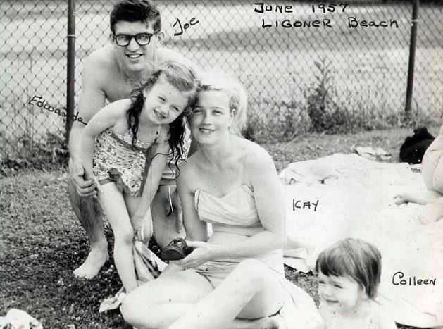 Black and white photo of a family at the beach.