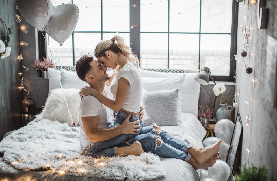 Couple embracing on a bed on Valentine's Day.