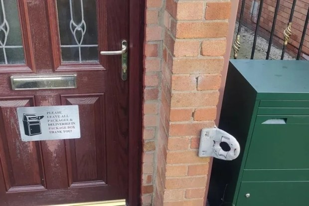 A green parcel box with a sign requesting deliveries be left inside.