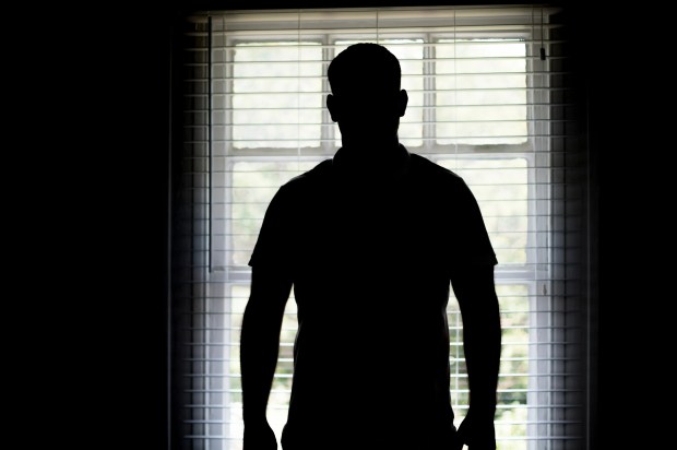 Silhouette of a man standing at a window.