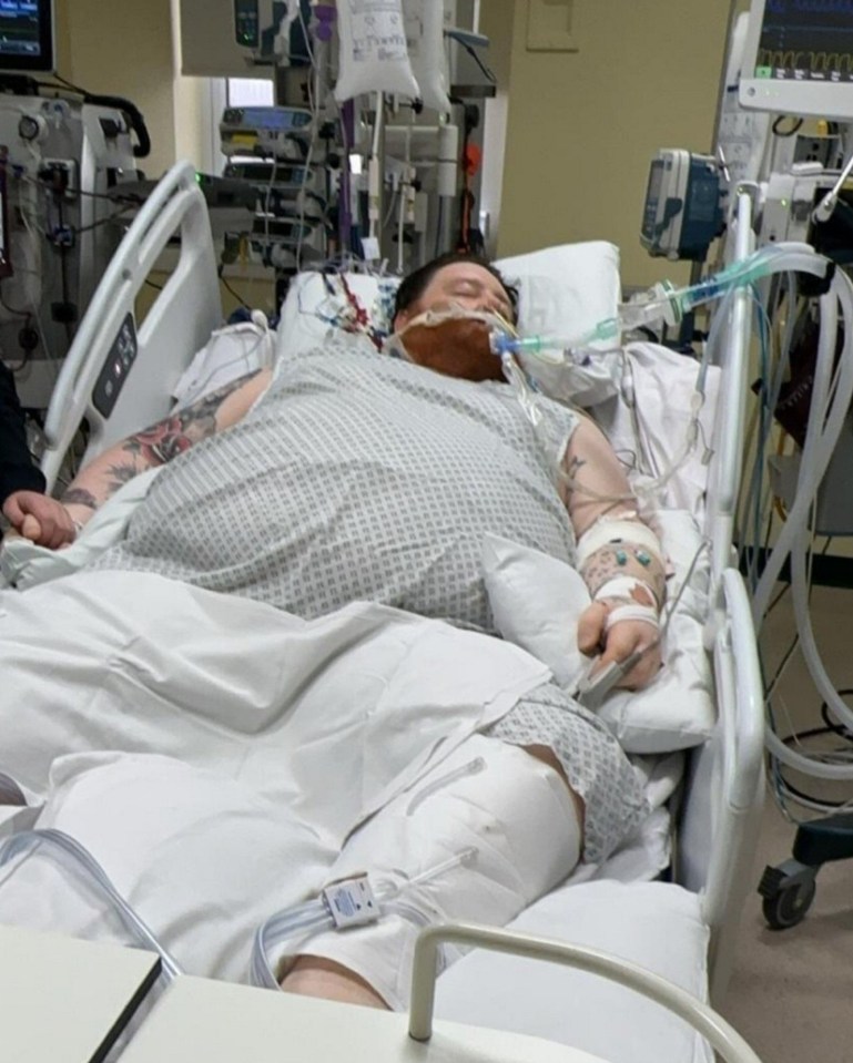 Man in hospital bed with medical equipment.