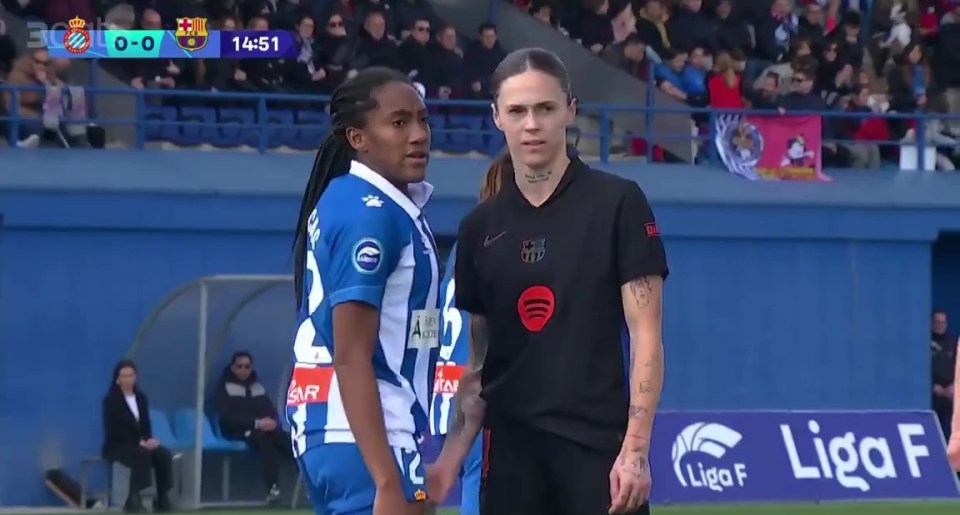 Two women's soccer players facing each other on the field.