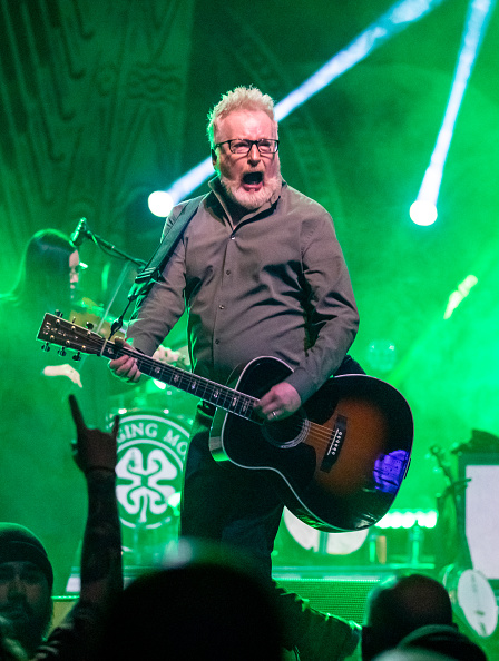 Dave King of Flocking Molly performing on stage with an acoustic guitar.