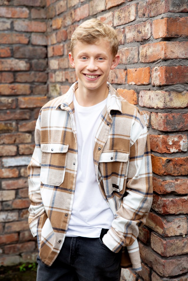 Portrait of a smiling teenage boy wearing a plaid shirt.