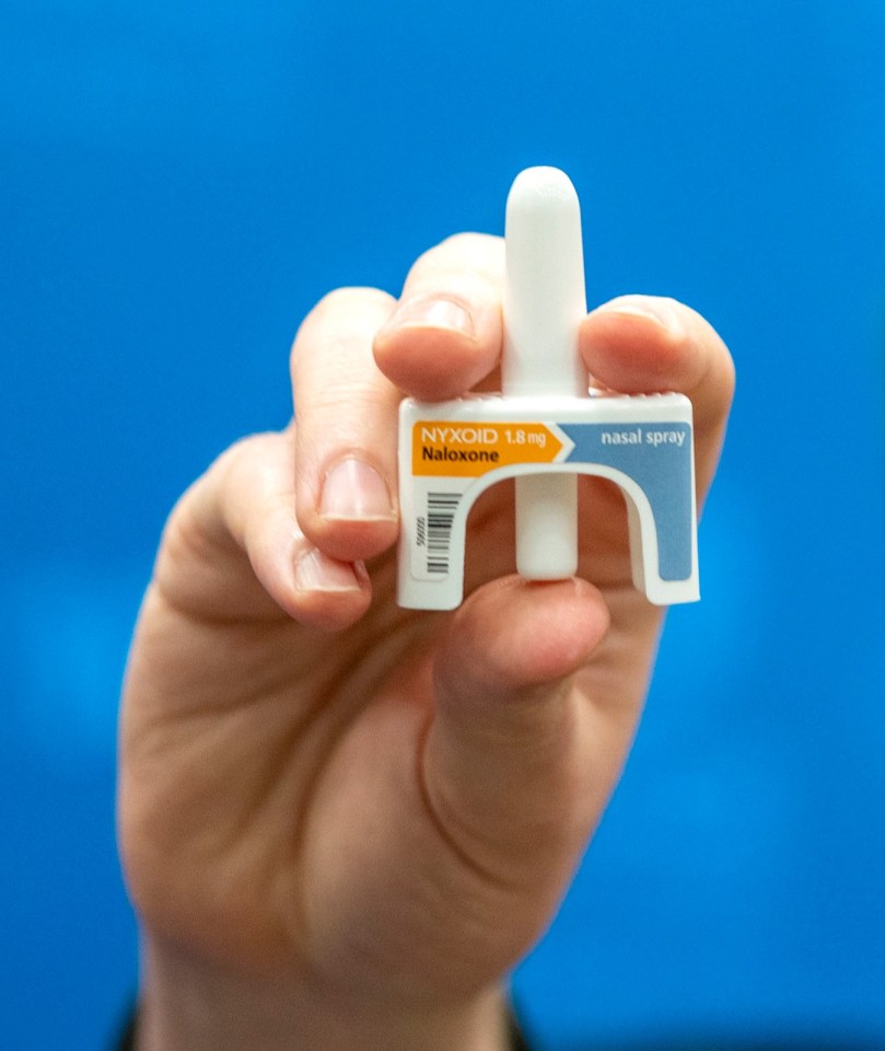 A police officer holding a naloxone nasal spray.