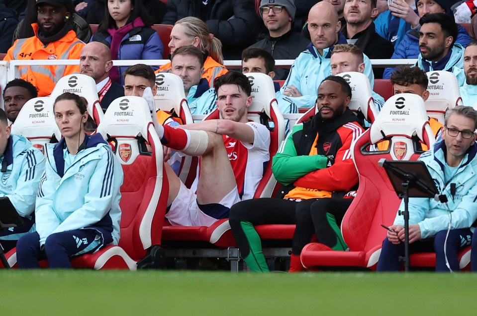 Arsenal players sitting on the bench.