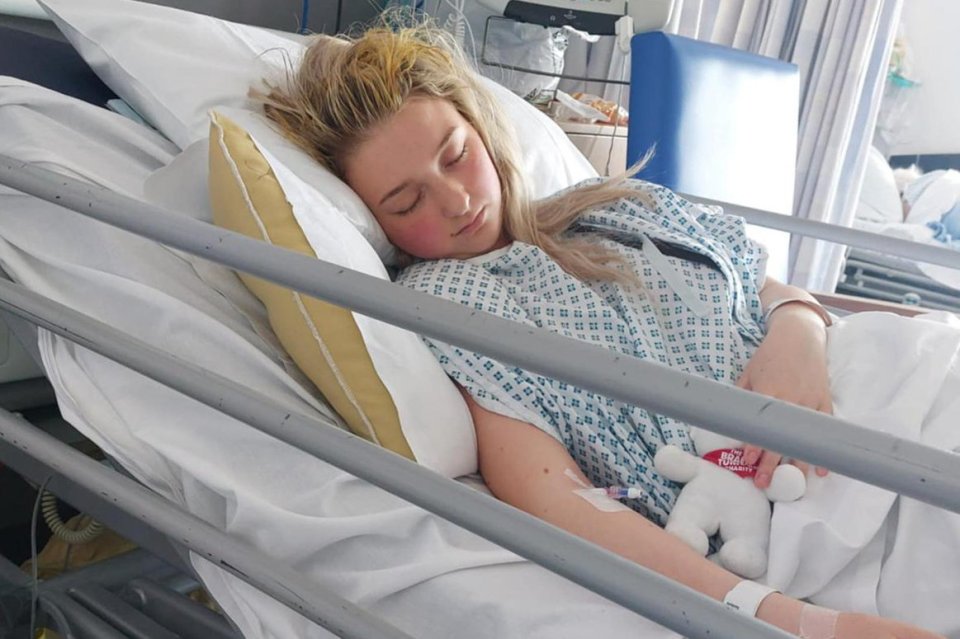 Teenage girl sleeping in a hospital bed.