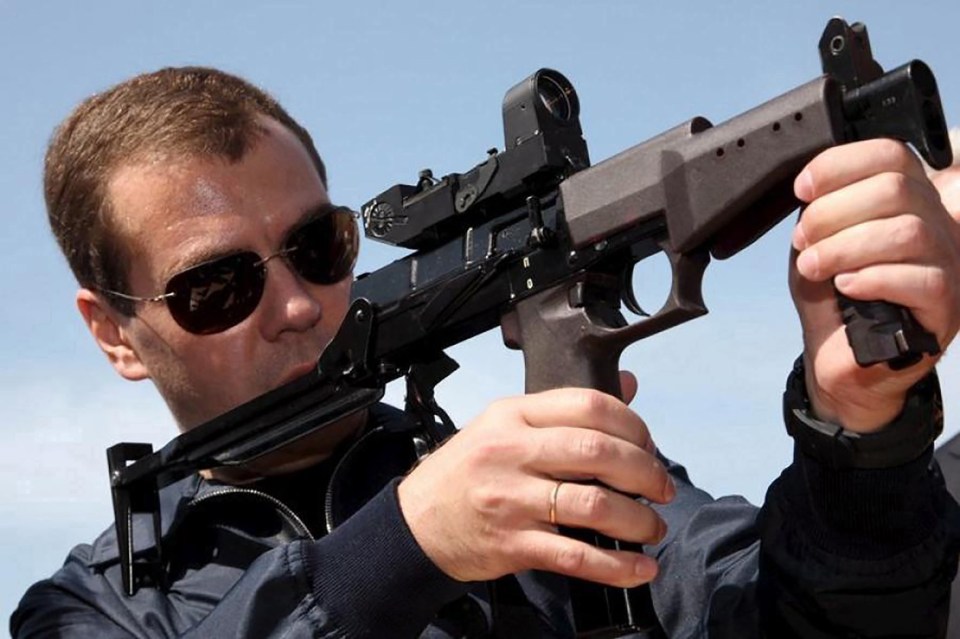 Dmitry Medvedev holding a firearm.