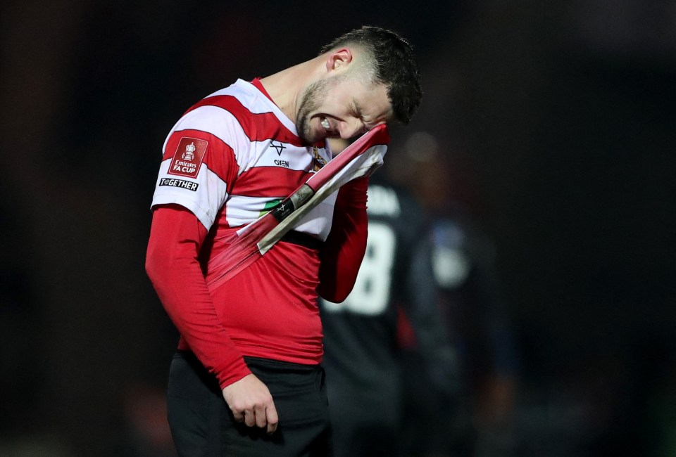 Soccer player wiping his face with his jersey.