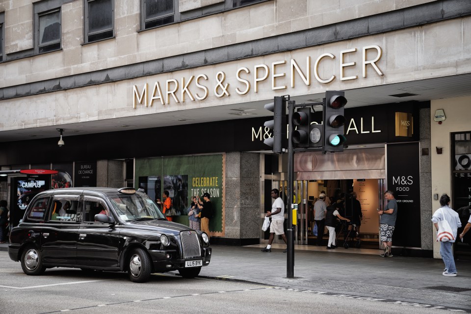 August 11, 2024 - City Of Westminster, Oxford Street & Orchard Street, London, W1 London, England, United Kingdom - Classic Black Cab, A famous London landmark. M&S Marks and Spencer Foodhall Supermarket & Gourmet grocery store, Central Core of London, Central London Street. the central business area. M&S Foodhall located near Marble Arch - Located next to Oxford Street ; One of the most famous shopping streets in the world. people waiting for buses, shopping or interacting with the Marks and Spencer Foodhall store.