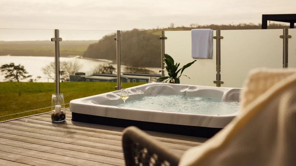 Hot tub on deck overlooking water.