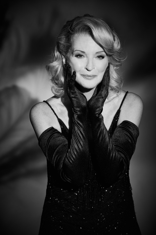 Black and white portrait of a woman in a black sequined dress and long gloves.