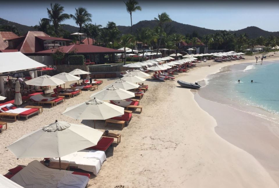 Beach scene with lounge chairs and umbrellas at Eden Rock Hotel, St. Barths.