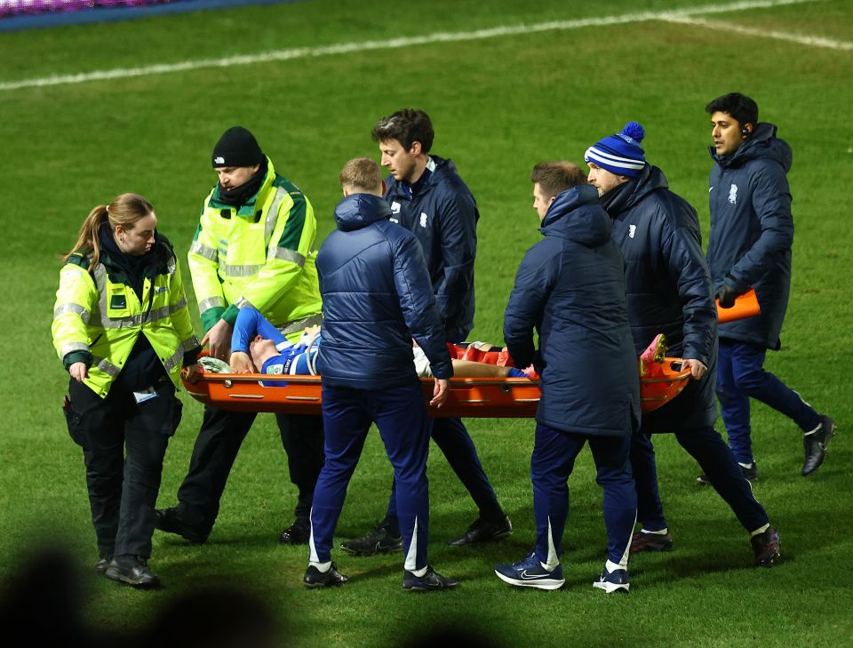 Injured soccer player being carried off the field on a stretcher.