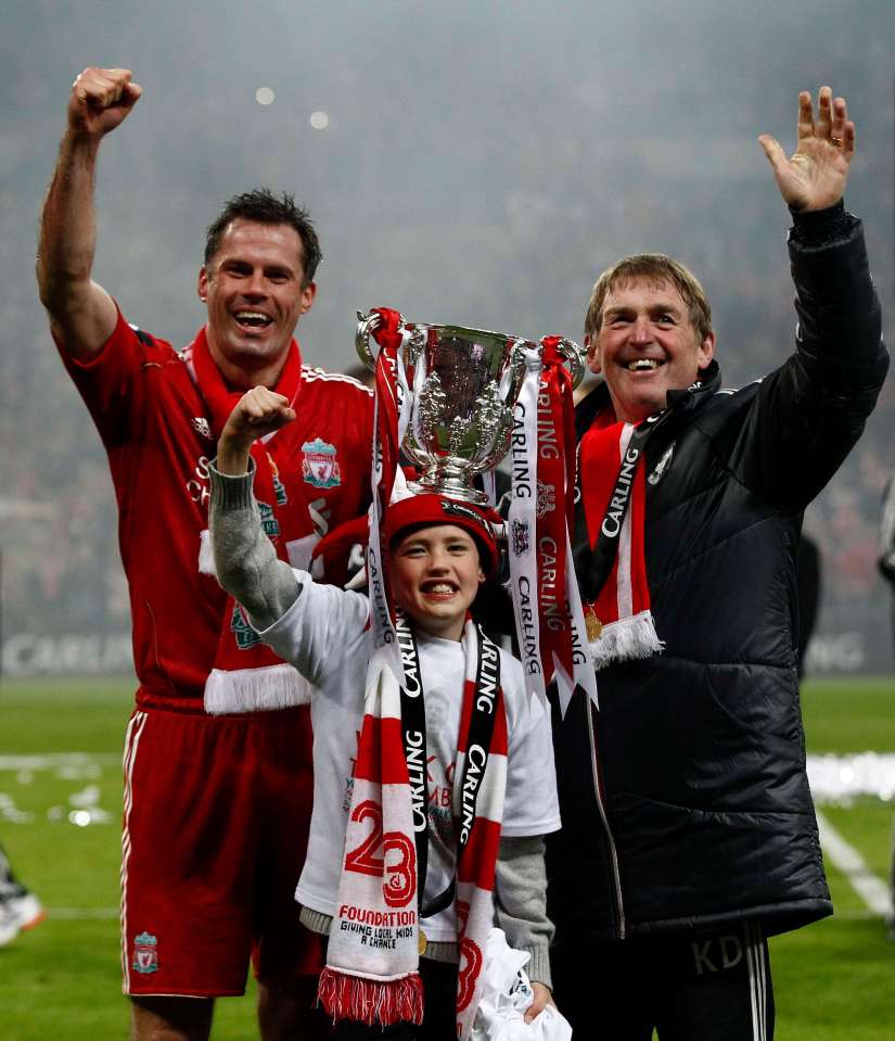 Jamie Carragher, his son, and Kenny Dalglish celebrating with a trophy.