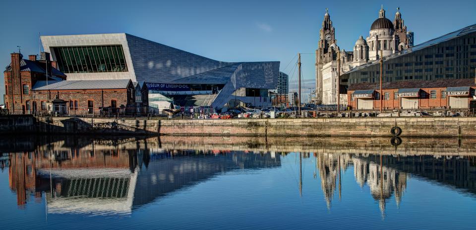 Liverpool waterfront with Museum of Liverpool and Royal Liver Building reflected in the water.