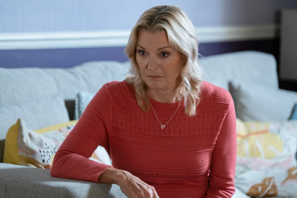 Kathy Beale from EastEnders in a red sweater.