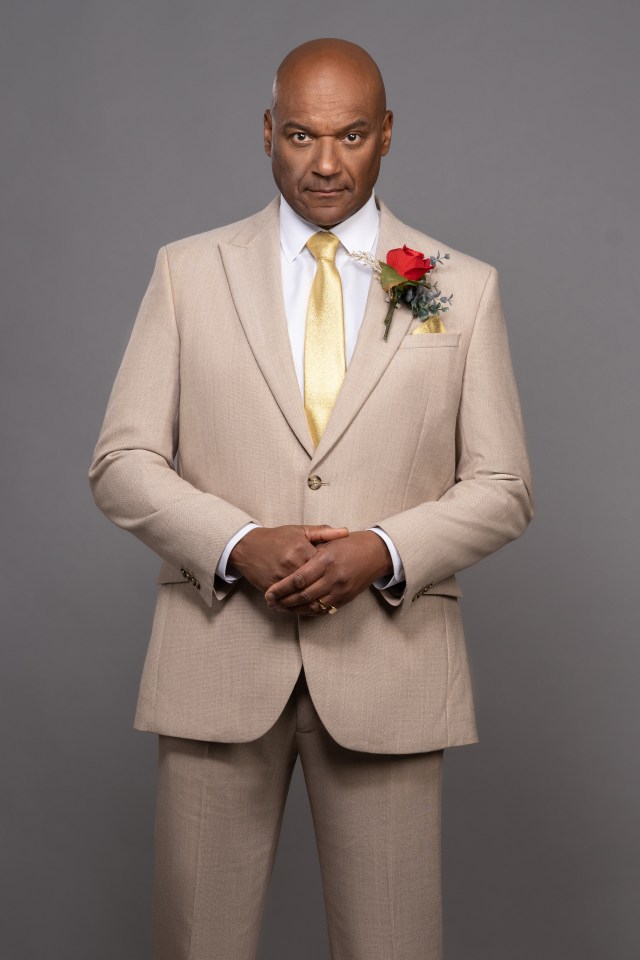 Portrait of Colin Salmon in a beige suit.