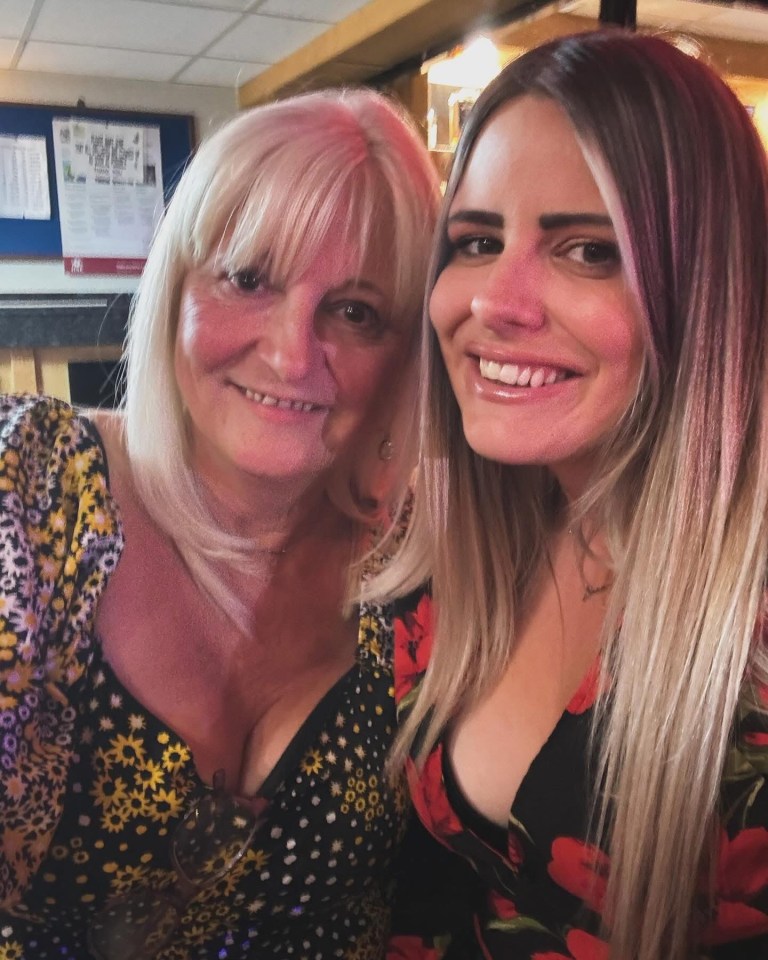 A mother and daughter smiling for a photo.