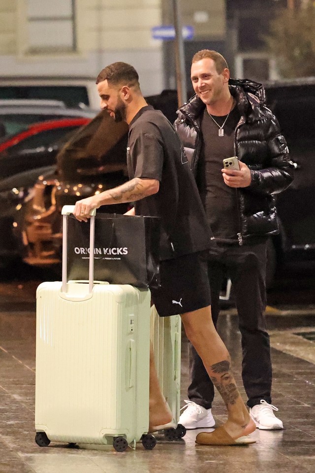 Kyle Walker with luggage outside a hotel.