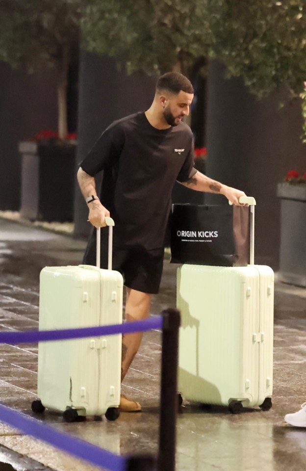 Kyle Walker with luggage outside a hotel.