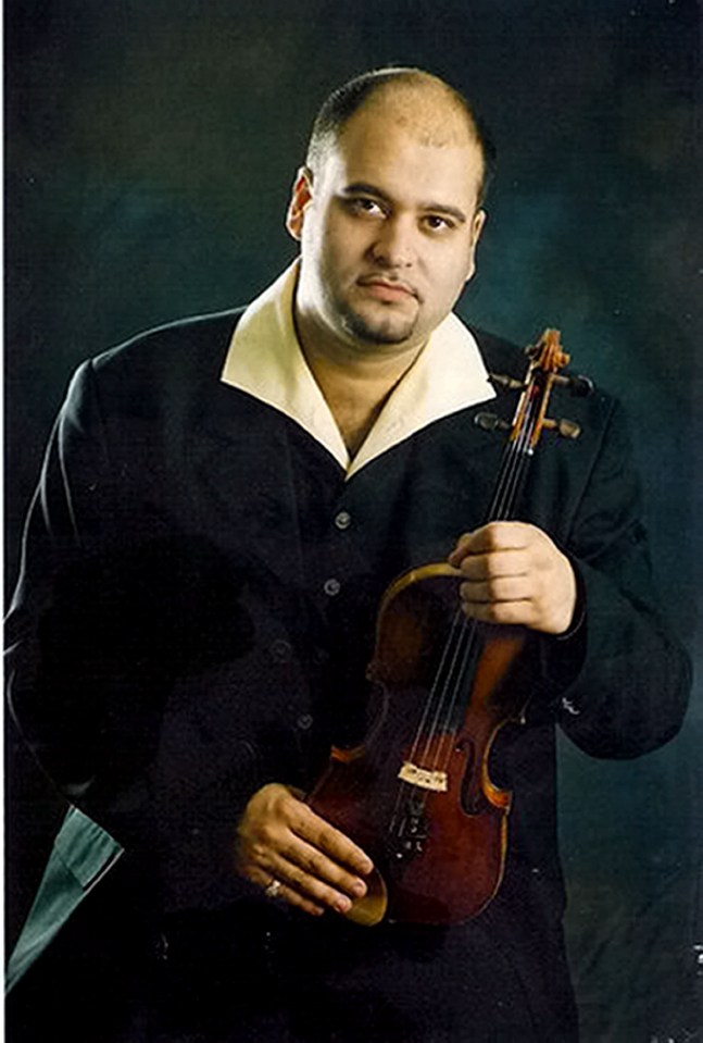 Portrait of Sandor Feher, a Hungarian violinist and violin teacher, holding his violin.