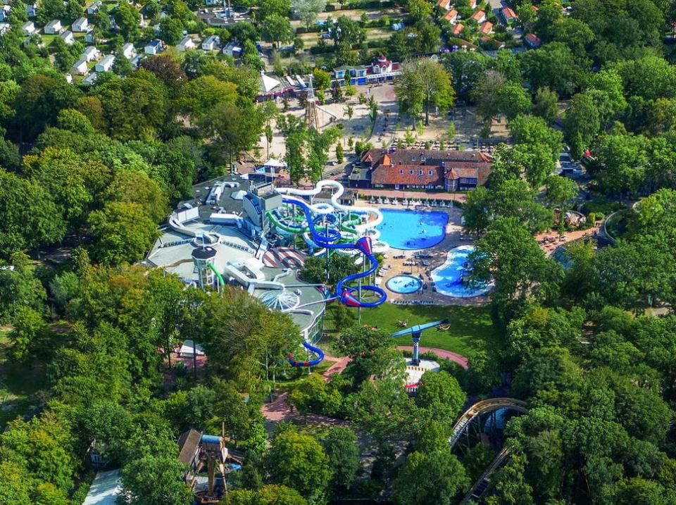 Aerial view of a water park with slides and pools surrounded by trees.