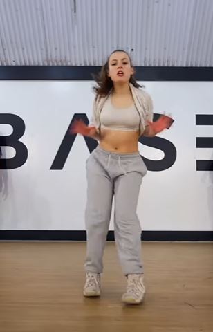 Woman in gray sweatpants dancing.