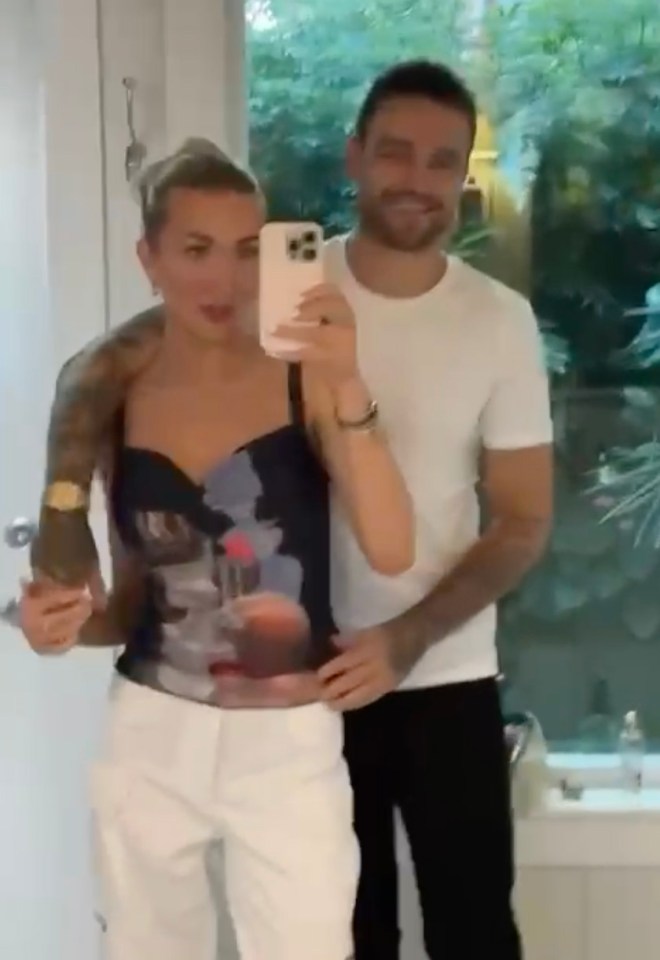 Mirror selfie of a couple; the woman holds a bottle of champagne.