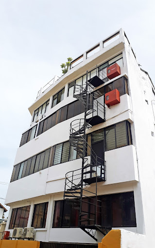 White building with exterior spiral staircase.