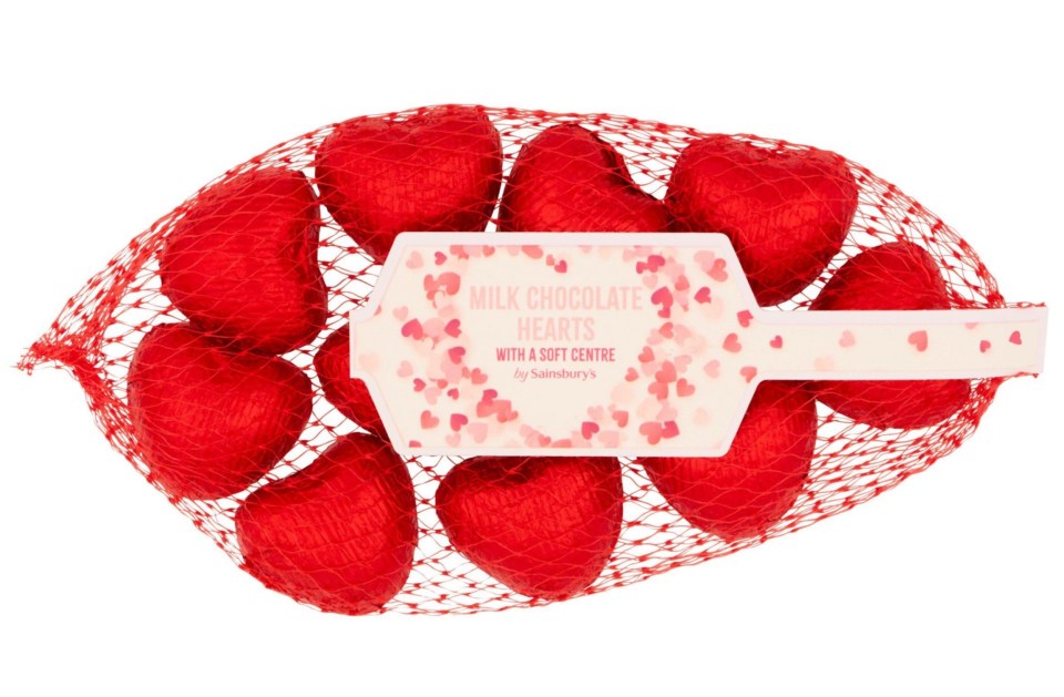 Milk chocolate hearts with a soft center in a red net bag.