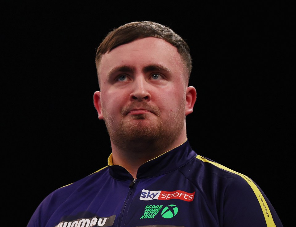 Luke Littler of England reacting during a darts match.