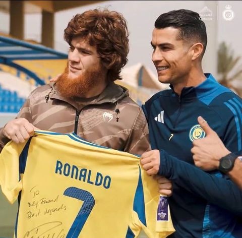 Cristiano Ronaldo with a fan, presenting a signed jersey.