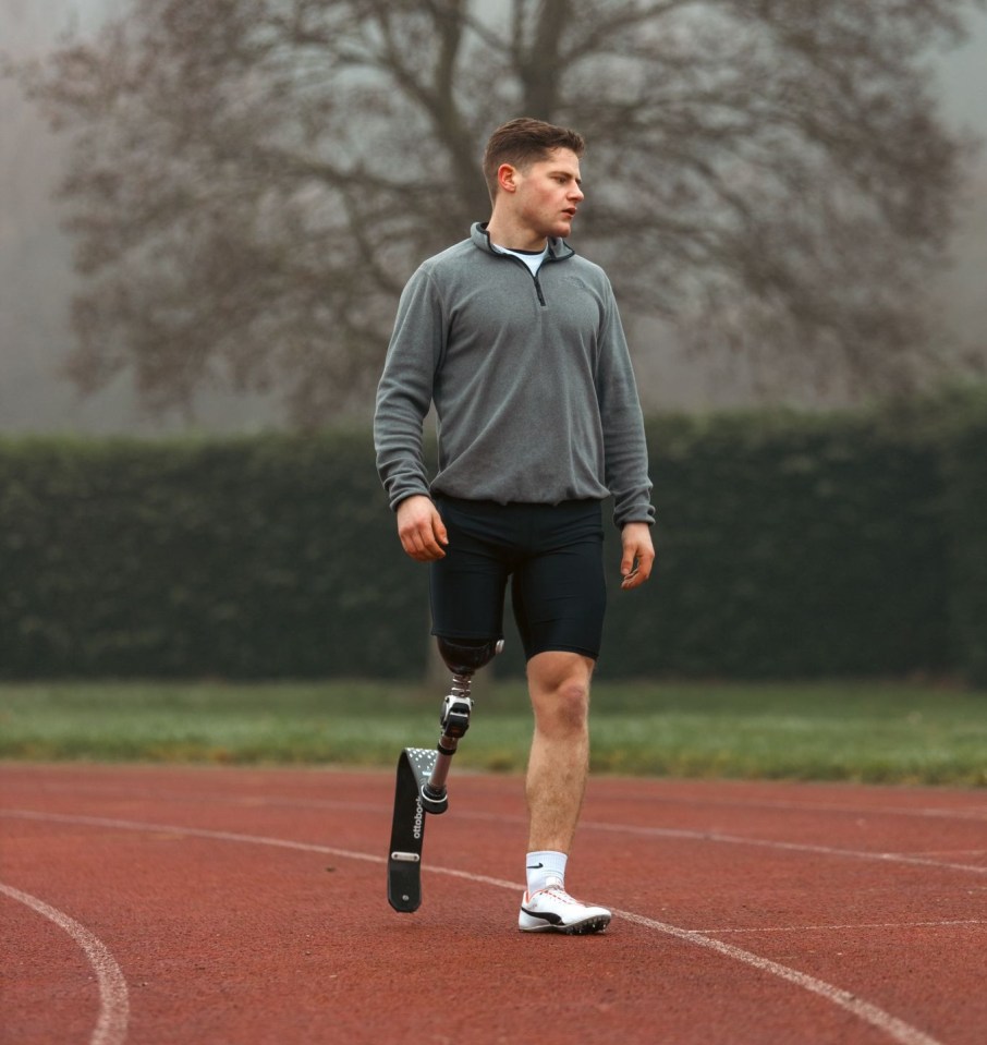 Athlete with prosthetic leg on running track.