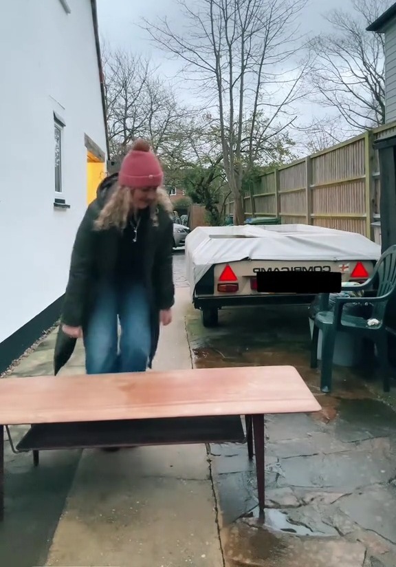 Woman carrying antique coffee table found in a skip.