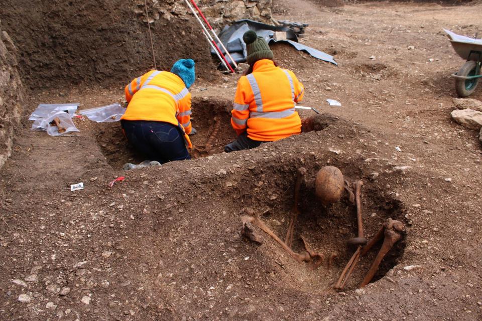 Archaeologists excavating a skeleton.