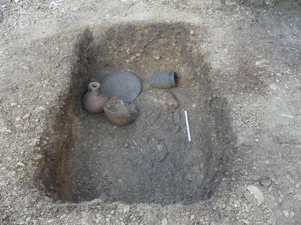 Archaeological dig site with pottery shards and vessels.