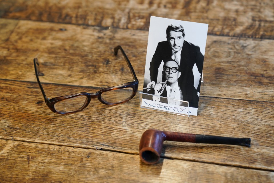 Eric Morecambe's glasses, pipe, and a photo of him and Ernie Wise.