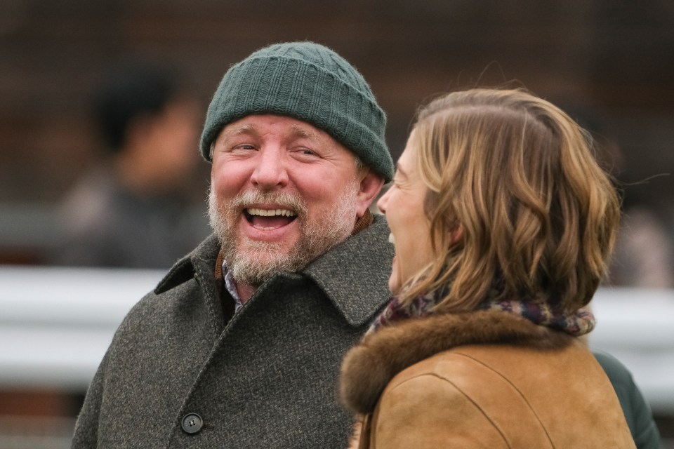 Guy Ritchie laughing at Sandown Park Racecourse.