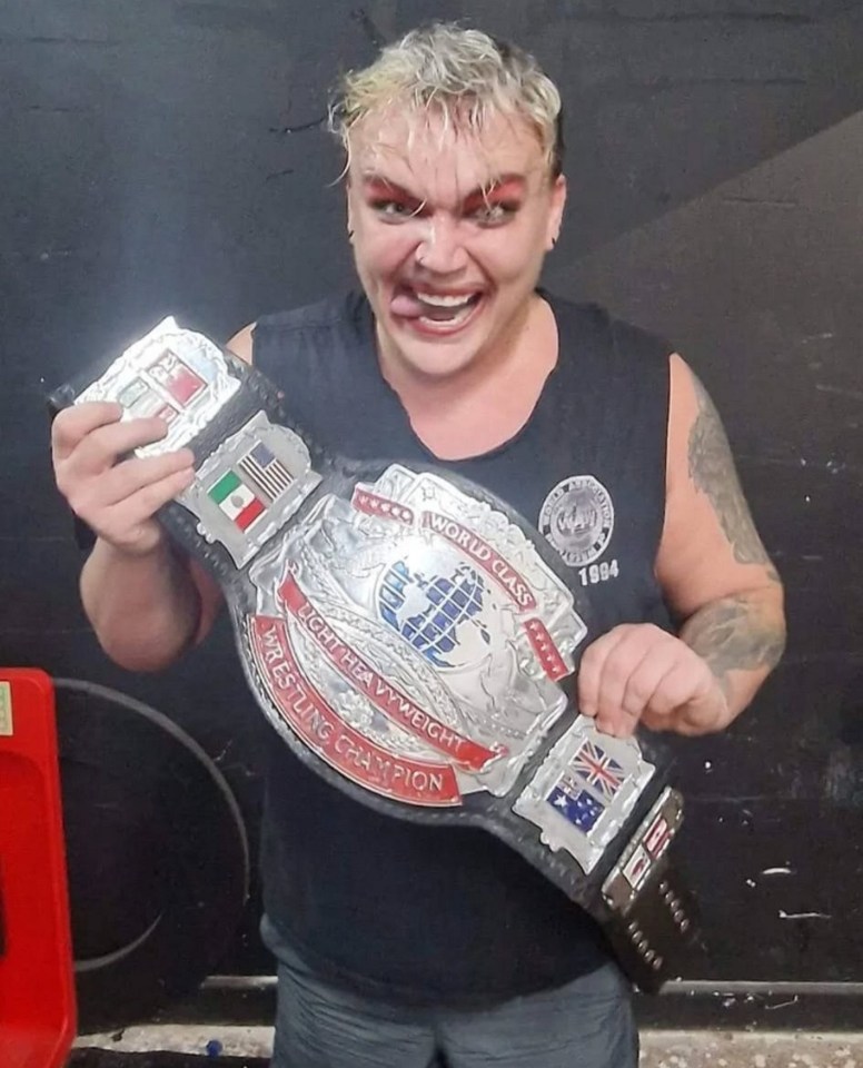 Lee Mitchell, a professional wrestler, holding a championship belt.