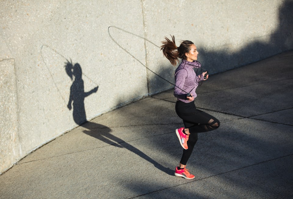 Woman jump roping outdoors.